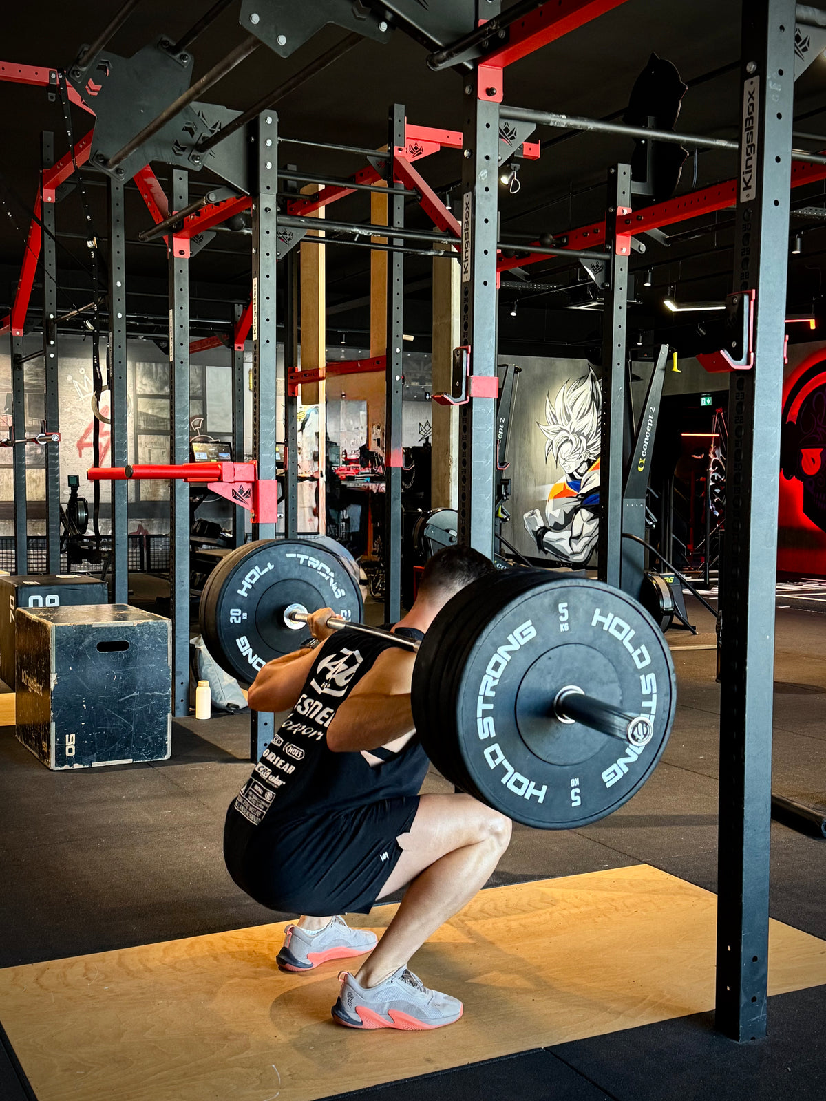 Athlète en back squat avec une barre chargée pendant sa séance de musculation